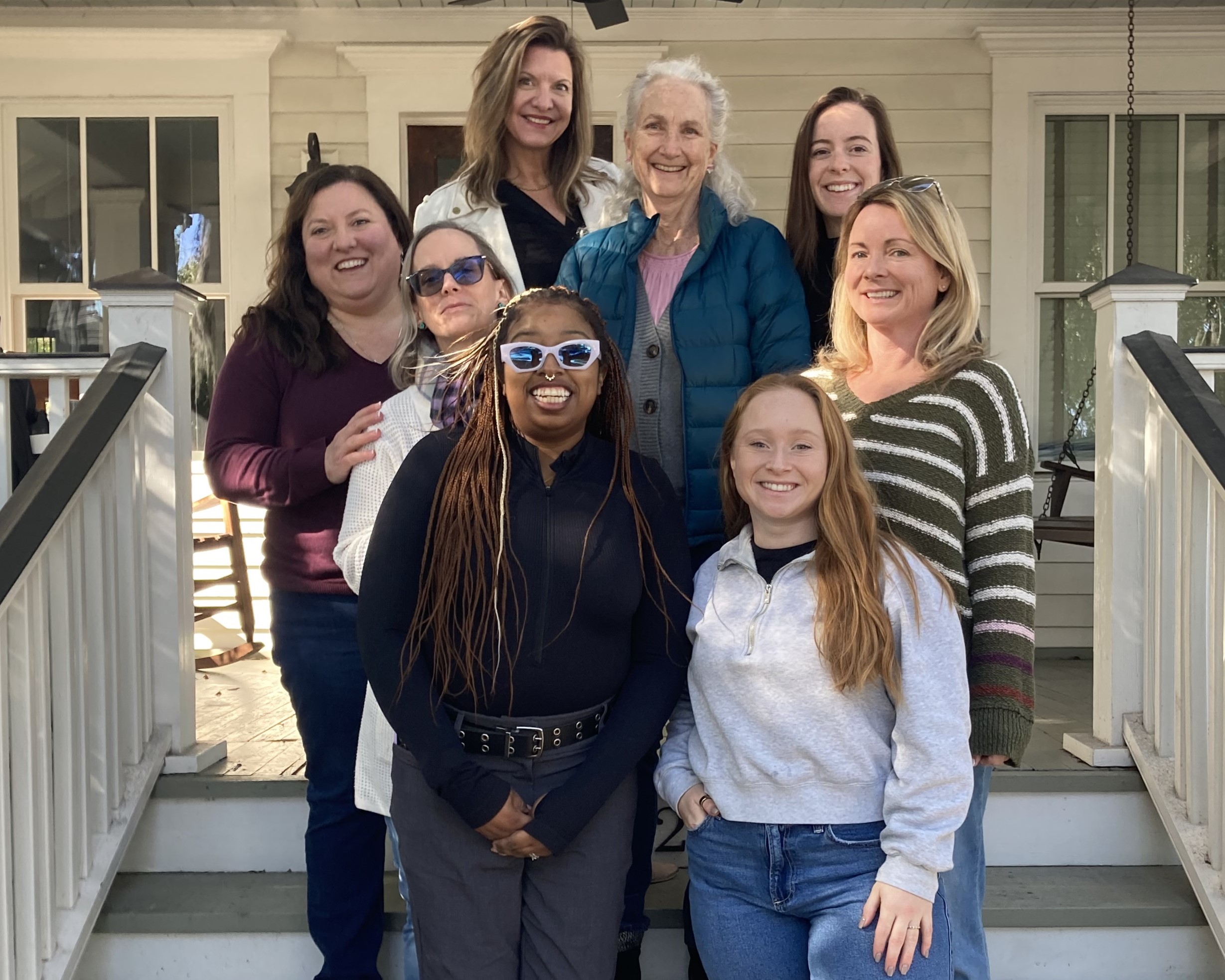 A diverse group of women standing on stairs